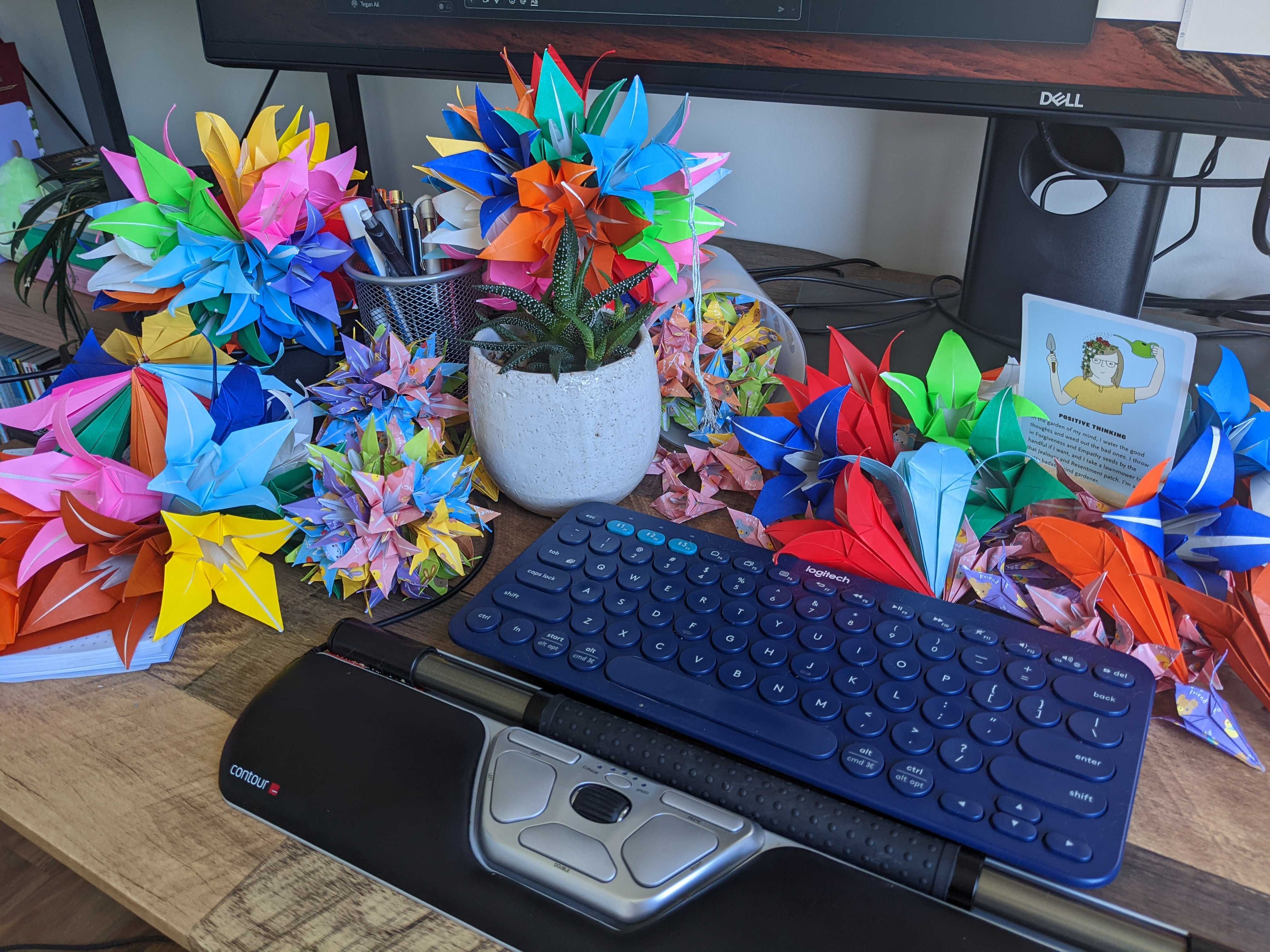 Photo of Trish's desk showing a keyboard surrounded by colorful origami flowers