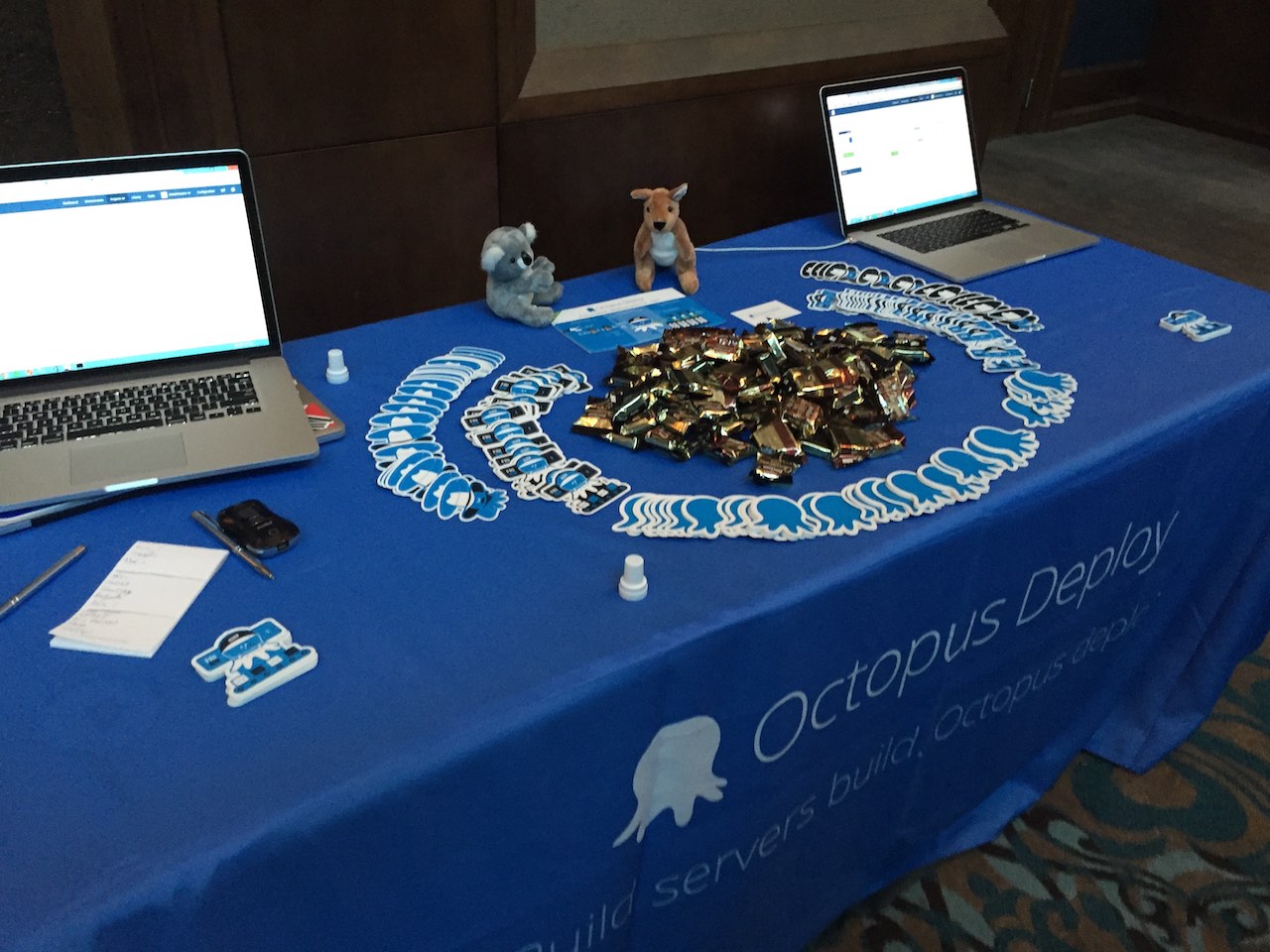 Octopus Deploy stickers and Tim Tams on a table with a blue Octopus Deploy table cloth